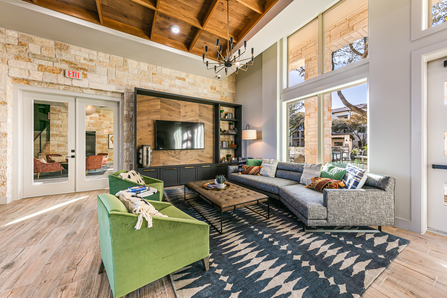 Clubhouse lounge area with large sofa, armchairs, and wall-mounted TV