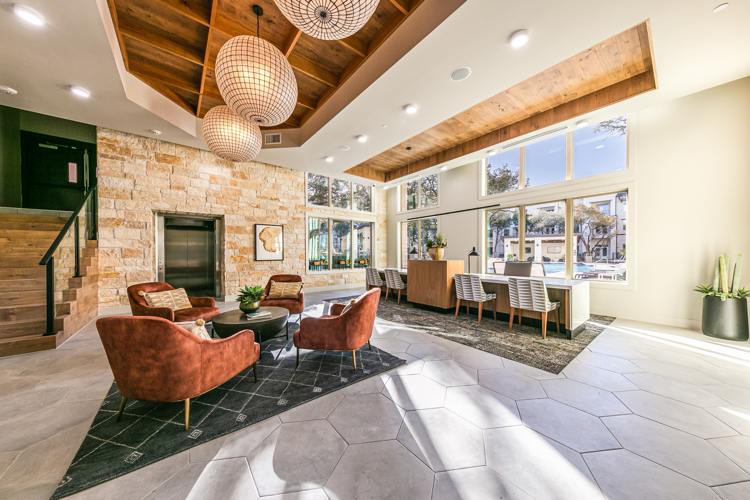 Clubhouse and leasing area with lounge seating, elevator, and windows looking into pool