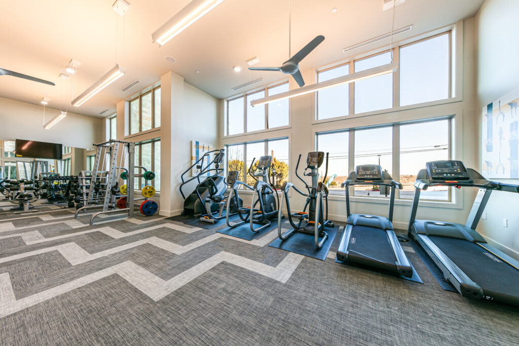 Fitness center with cardio machines and ceiling fans