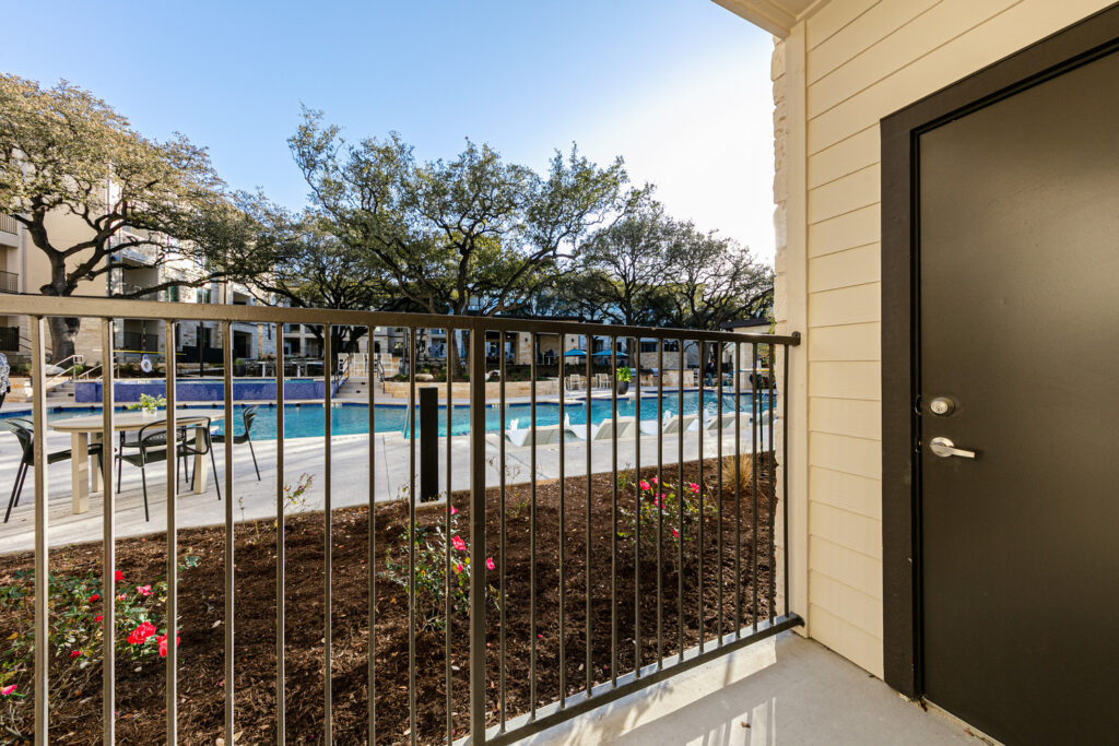 Model apartment patio with storage room and view of pool courtyard