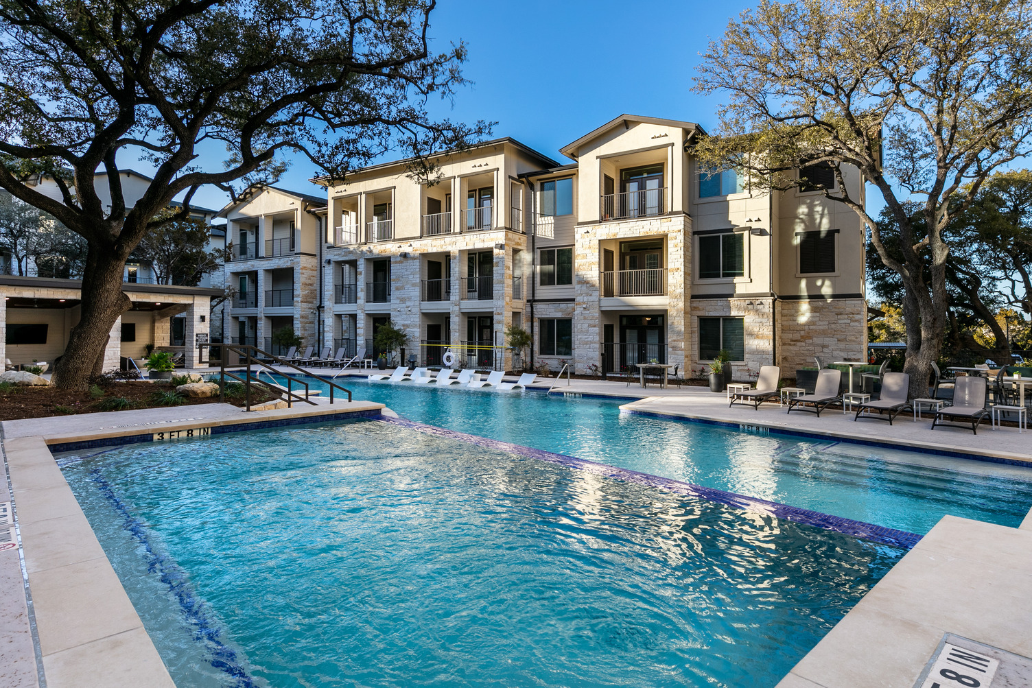 Resort-style pool courtyard with seating throughout and landscaping