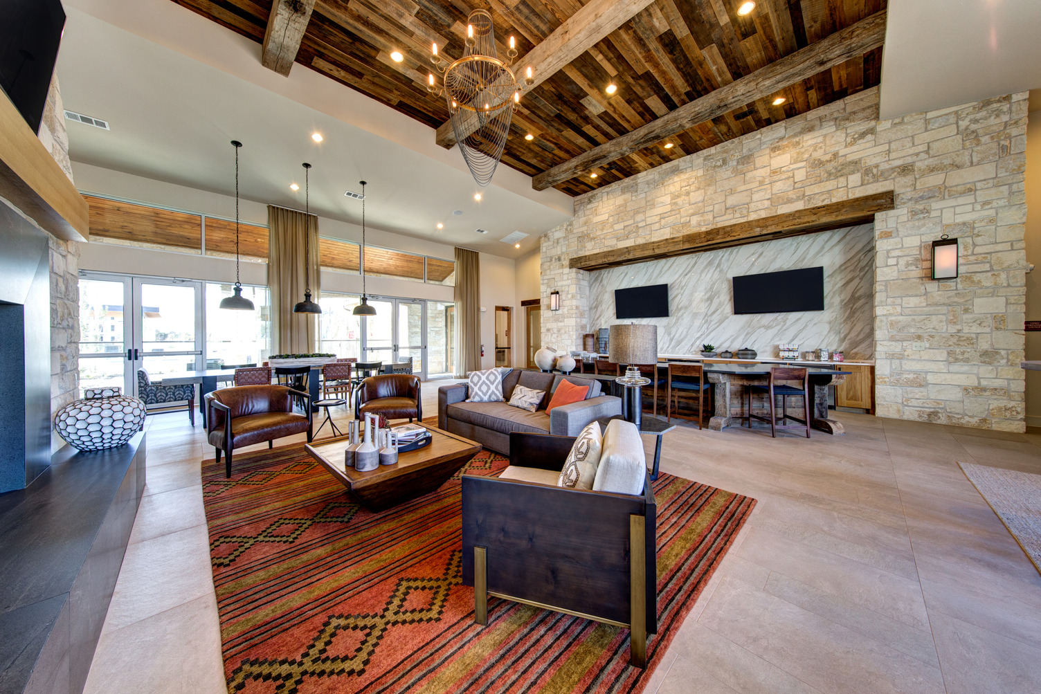 Clubroom seating area with fireplace lounging area and demonstration kitchen with wall-mount TVs