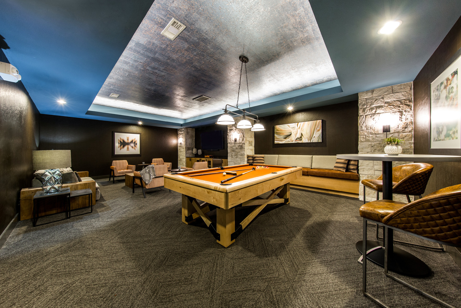 Wide view of gaming room with lounge seating and pool table