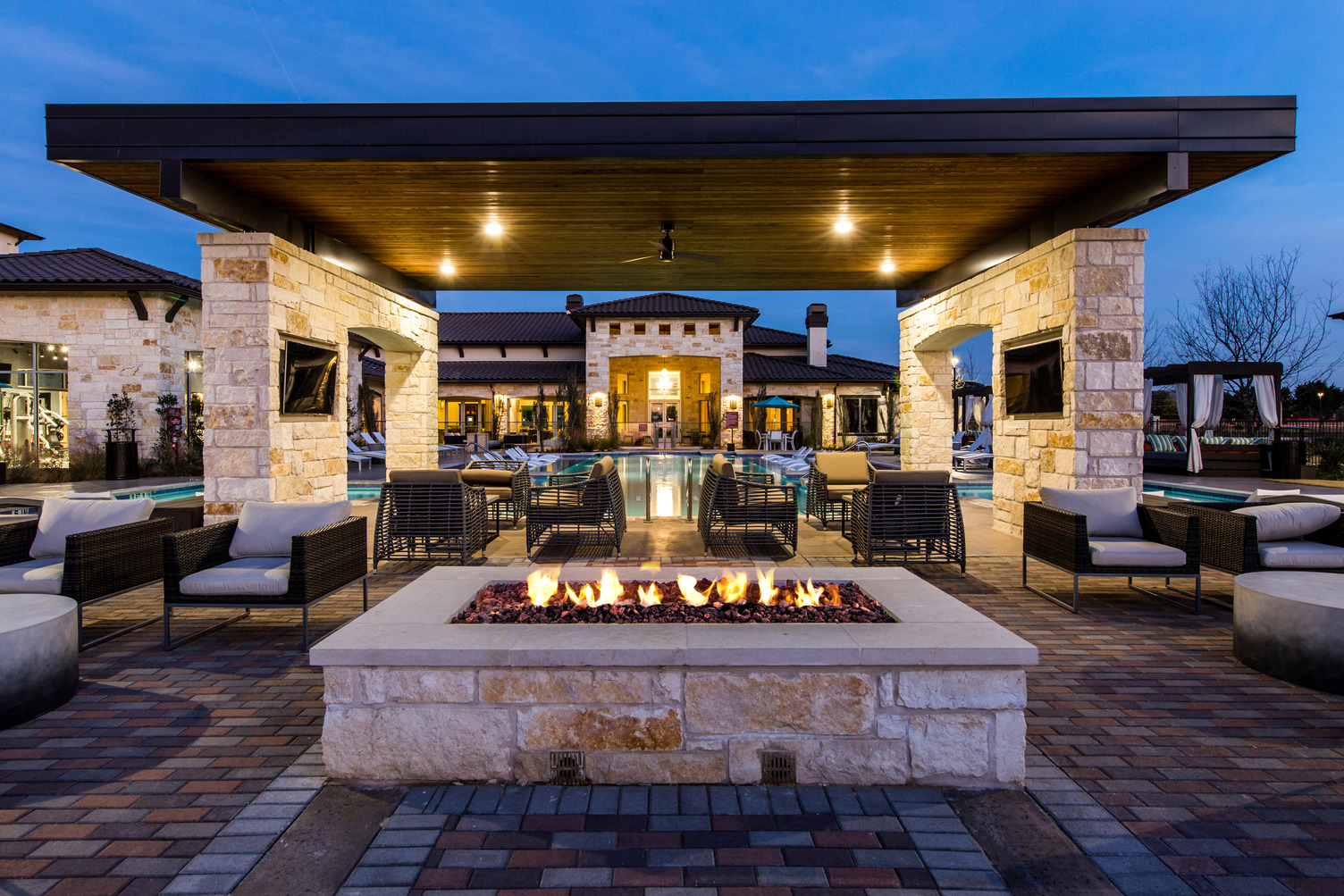 View of pool courtyard at dusk with fire pit