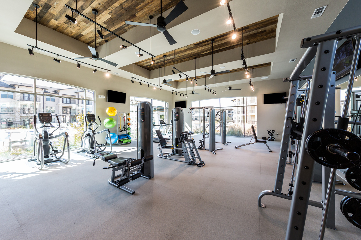 Fitness center with cardio machines, strength training equipment, and free weights