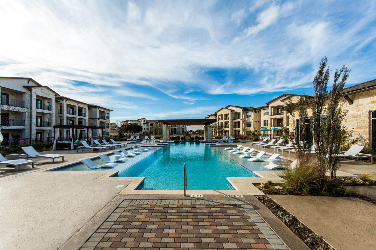 Resort-style pool courtyard with lounge seating throughout