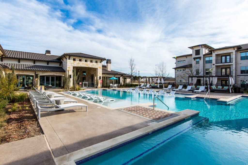 Resort-style swimming pool courtyard with lounge seating and landscaping