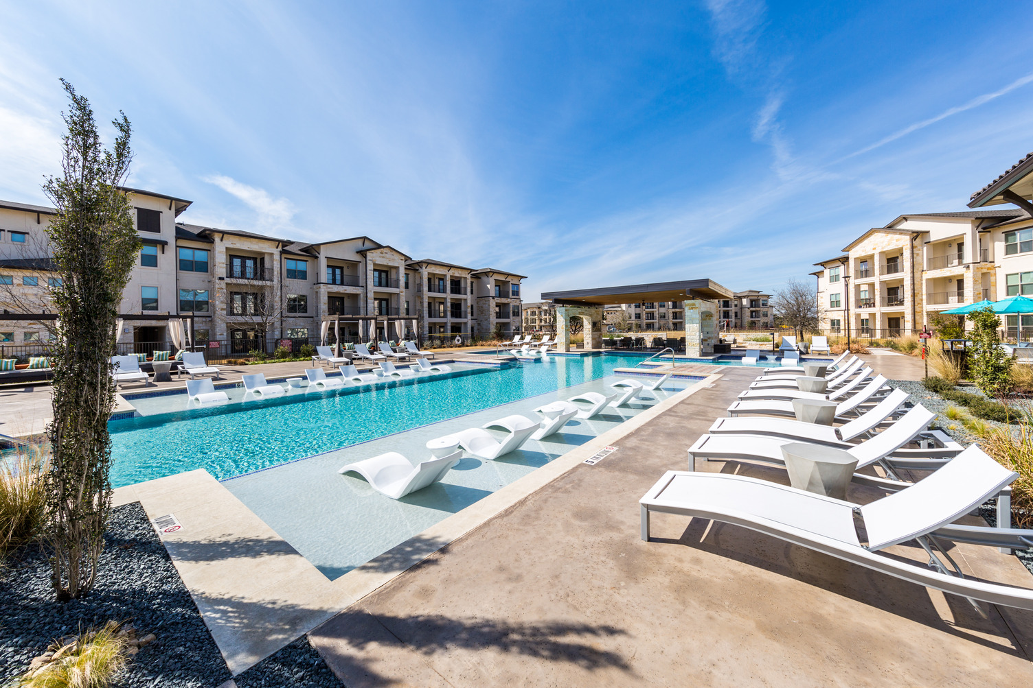 Swimming pool courtyard and in-pool loungers and additional seating