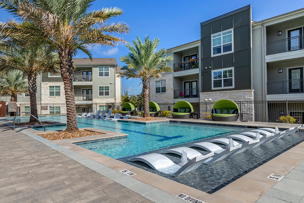View of pool deck and courtyard with lounge seating
